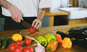 Person Cutting a Tomato
