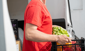 Man in Red Crew Neck T-shirt Holding Black Basket