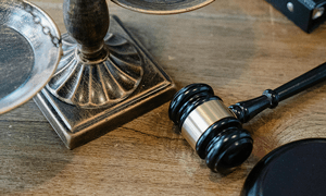 Justice Scales and Gavel on Wooden Surface