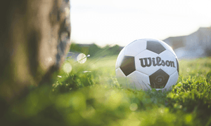 White and Black Soccer Ball on Green Grass Field