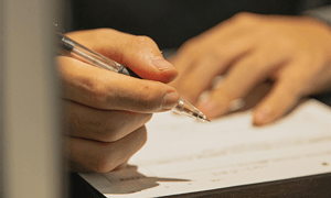 Person writing with pen on paper